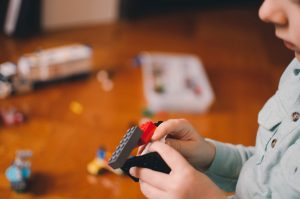 child's hands building legos